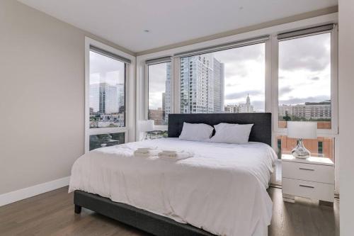 ein weißes Schlafzimmer mit einem großen Bett und Fenstern in der Unterkunft 2 Newly Built Luxury Condos with Private Roofdeck in Chicago