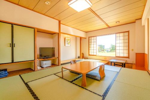 a living room with a coffee table and a tv at Ooedo Onsen Monogatari Premium Hotel Sokan in Matsushima