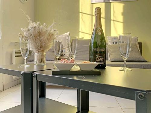 - une table avec une bouteille de vin et des verres dans l'établissement Maison 2 chambres, jardin clos, proche plage, parking privé - FR-1-646-60, à Berck-sur-Mer