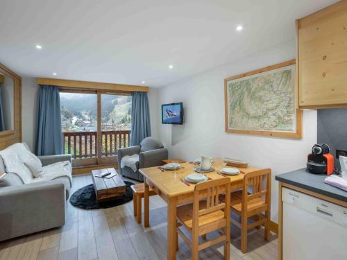 une cuisine et un salon avec une table et un canapé dans l'établissement Charmant appartement à Méribel, bien équipé, 4 pers, proche pistes et commerces - FR-1-565-105, à Les Allues