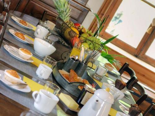 a table with plates of food on top at Gîte chaleureux avec cheminée, espace jeux et animaux, proche nature et activités familiales - FR-1-496-315 in Sauvain