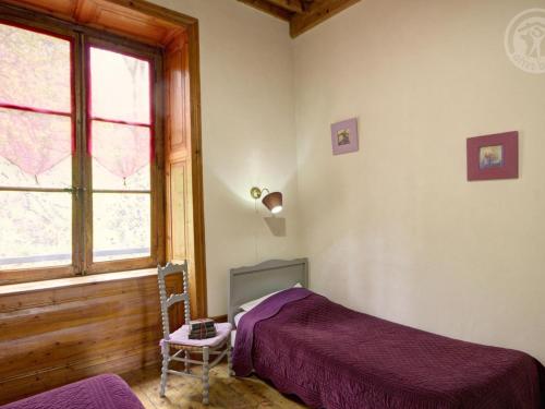 a bedroom with a bed and a window and a chair at Gîte chaleureux avec cheminée, espace jeux et animaux, proche nature et activités familiales - FR-1-496-315 in Sauvain