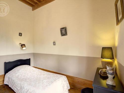 a bedroom with a bed and a desk with a lamp at Gîte chaleureux avec cheminée, espace jeux et animaux, proche nature et activités familiales - FR-1-496-315 in Sauvain