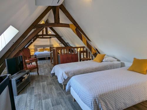 Cette chambre mansardée comprend 2 lits et une télévision. dans l'établissement Gîte de charme rénové à Châteauroux, jardin privé, jusqu'à 10 pers, proche centre et Belle-Isle - FR-1-591-581, à Châteauroux