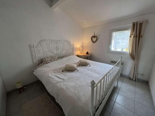 ein Schlafzimmer mit einem weißen Bett mit zwei Kissen darauf in der Unterkunft Appartement Valras-Plage, 3 pièces, 4 personnes - FR-1-701-78 in Valras-Plage