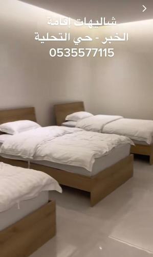 two beds in a room with a sign on the wall at شاليهات اقامة in Al Khobar