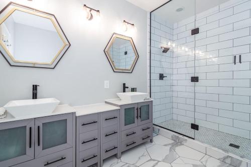 a white bathroom with two sinks and a mirror at Eclectic Stylish and Cozy Milwaukee Home in Milwaukee