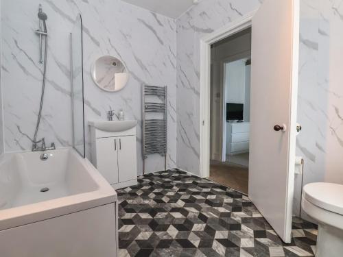 Un baño blanco con lavabo e inodoro. en Mariners Lee, en Llandudno