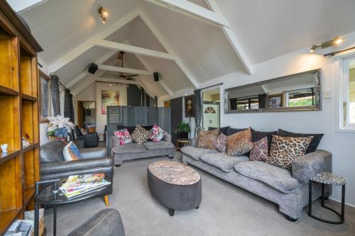 a living room with couches and a table at Alpine Rock B&B in Te Anau