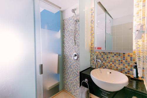 a bathroom with a sink and a shower at Kuta Beach Hotel in Kuta