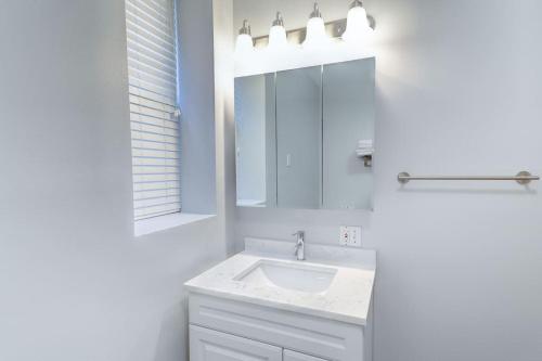 a white bathroom with a sink and a mirror at Central Chicago Suite2 Access to Patio in Chicago