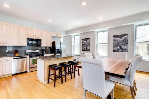 a kitchen with a wooden table and white chairs at Stunning 2 Floor Penthouse Downtown in Chicago