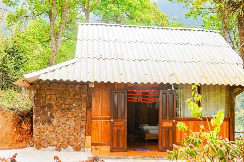 ein kleines Haus mit einem Metalldach und einer Tür in der Unterkunft A Dế Homestay Sơn Tra in Phong Thổ