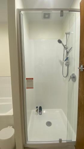a bathroom with a shower with a glass door at 3 Bedroom Home by the Reserve in Rotorua