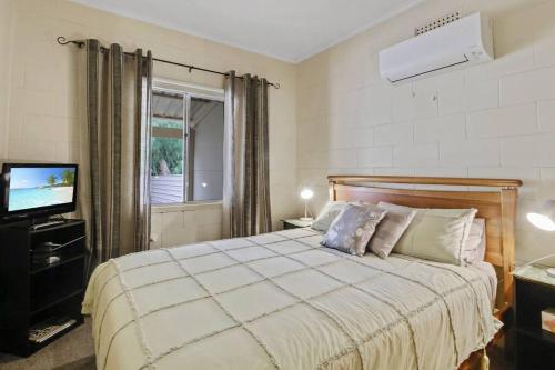 1 dormitorio con 1 cama grande y TV en Bonney Shores en Barmera