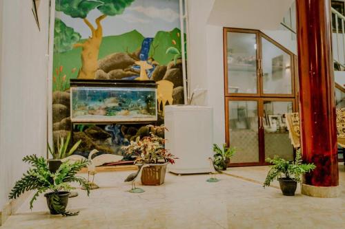 Zimmer mit Topfpflanzen und Wandgemälde in der Unterkunft Lihini Villa ii in Matara