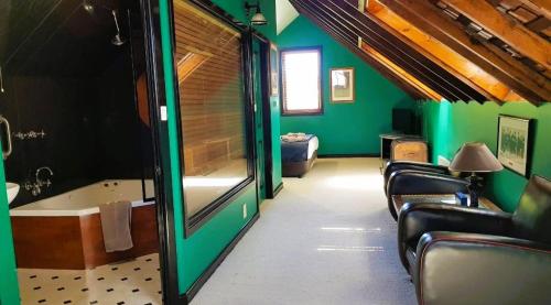 a bathroom with green walls and a tub and chairs at The Camperdown Mill in Camperdown