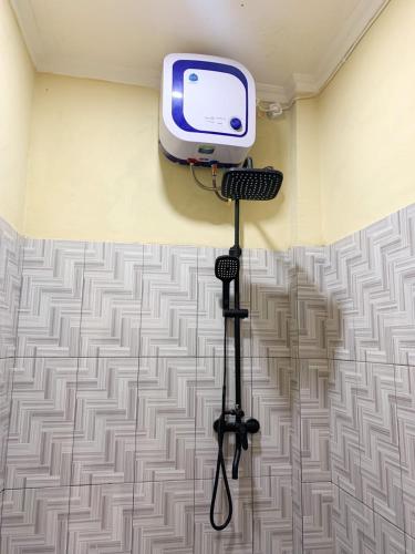 a television on a tripod in a room with a wall at FX72 Labuan Bajo Hotel in Labuan Bajo