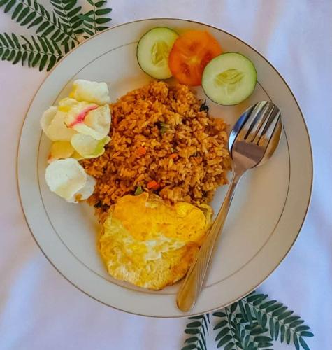 a plate of food with fried rice and vegetables at FX72 Labuan Bajo Hotel in Labuan Bajo