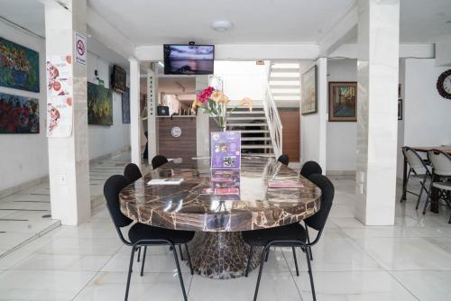 a dining room with a glass table and chairs at Hotel del Arte y Figura in León