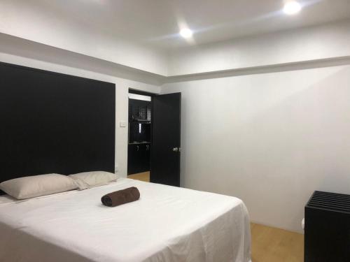 a bedroom with a white bed with a brown bag on it at Holiday Hire Fiji in Lautoka