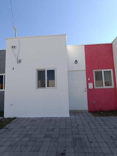 a white and red building with two windows at Mini casa Ecoterra Santa Ana in Santa Ana