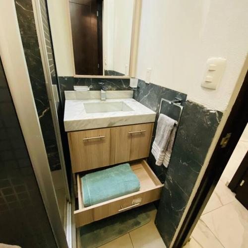La petite salle de bains est pourvue d'un lavabo et d'un miroir. dans l'établissement Depto céntrico y vista increíble, à Mexico