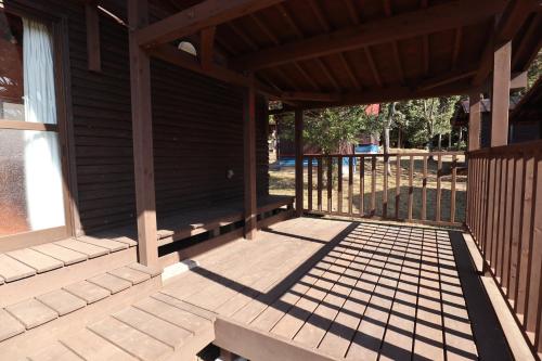 an empty porch of a wooden cabin with a window at Jisso Youth travel village in Yamano