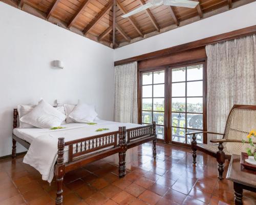 a bedroom with a bed and a large window at Closenberg Hotel in Galle
