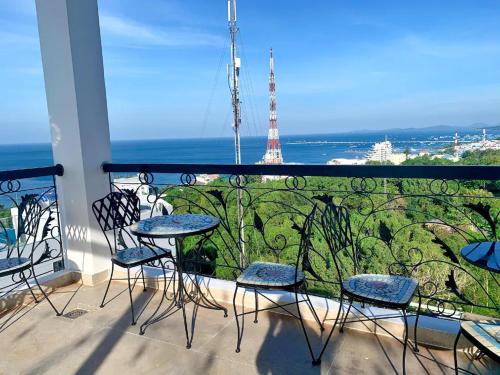 a balcony with chairs and a view of the eiffel tower at Maison Hotel PQ - by BAY LUXURY in Phu Quoc