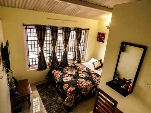 a bedroom with a bed and a mirror and a window at Heaven Bungalow in Ooty