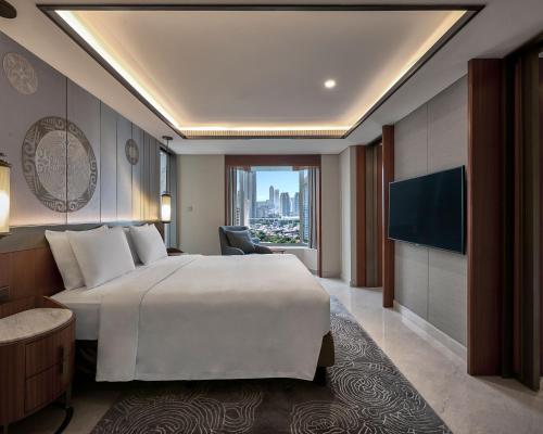 a hotel room with a large bed and a television at Grand Hyatt Jakarta in Jakarta