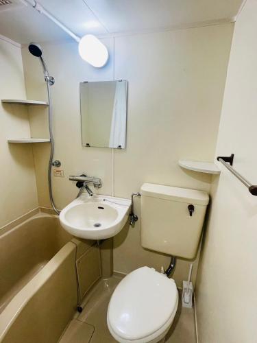 a small bathroom with a toilet and a sink at LIONS YONEGAHAMA l 米が浜通 in Yokosuka