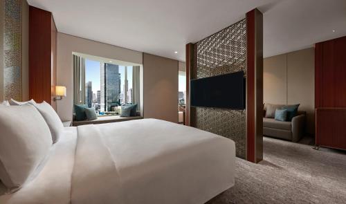 a bedroom with a large white bed and a television at Grand Hyatt Jakarta in Jakarta