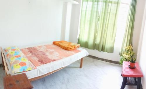 Habitación pequeña con cama y ventana en Serendipia en Dimāpur