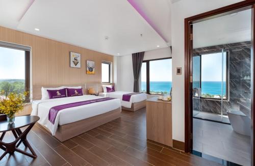 a bedroom with two beds and a view of the ocean at Maison Hotel PQ - by BAY LUXURY in Phu Quoc