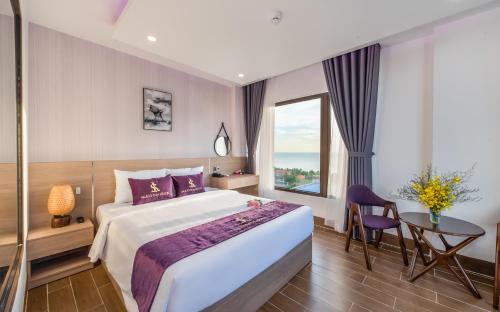 a hotel room with a large bed and a window at Maison Hotel PQ - by BAY LUXURY in Phu Quoc