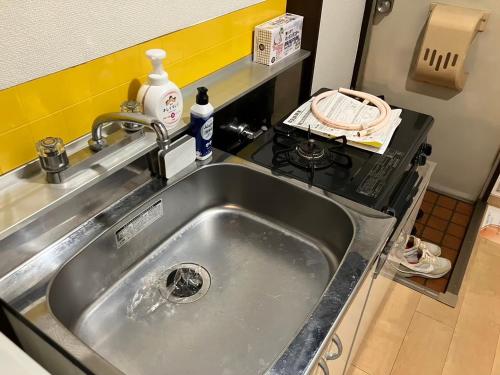 a stainless steel sink in a kitchen with a stove at Luna Heights Miyake by Tranova in Kichijōji