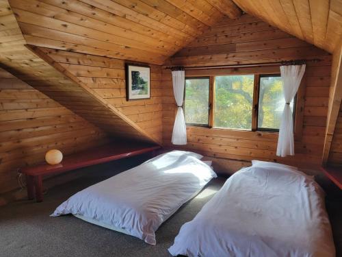 sypialnia z 2 łóżkami w drewnianym domku w obiekcie Renesto aHOLIDAYHOME - Vacation STAY 28000v w mieście Kobe