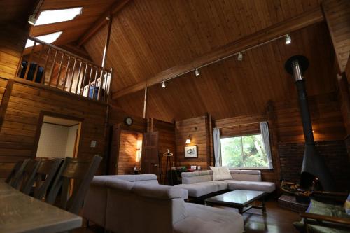 a living room with white furniture and a wooden ceiling at Renesto aHOLIDAYHOME - Vacation STAY 27984v in Kobe