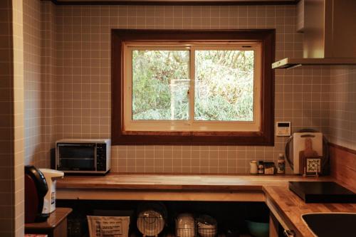 神戸市にあるRenesto aHOLIDAYHOME - Vacation STAY 27984vのキッチンの角に窓付きのキッチン