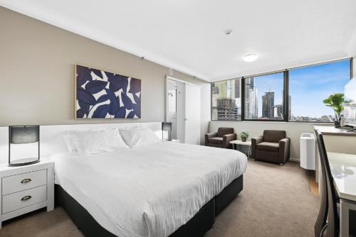 Central Brisbane Studio with Stunning River Views في بريزبين: غرفة نوم بسرير كبير ومكتب وكراسي