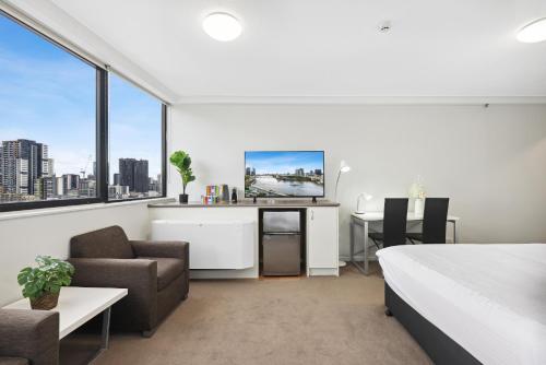 1 dormitorio con cama, escritorio y silla en Central Brisbane Studio with Stunning River Views, en Brisbane