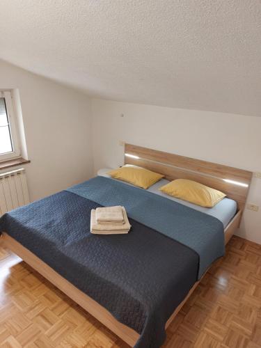 een slaapkamer met een bed met blauwe lakens en gele kussens bij Apartma BALC in Koper