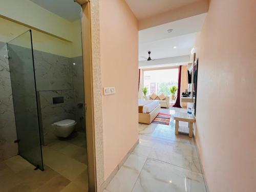 ein Bad mit einer Dusche und einem WC in einem Zimmer in der Unterkunft The Tirath Palace Luxury Hotel In Haridwar in Haridwar