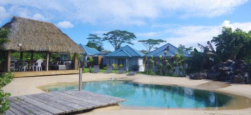 un complejo con piscina y cabaña en Vai Iti Lodge en Afaahiti