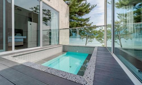 an indoor swimming pool in a house with glass walls at Goseong hansan marina in Goseong