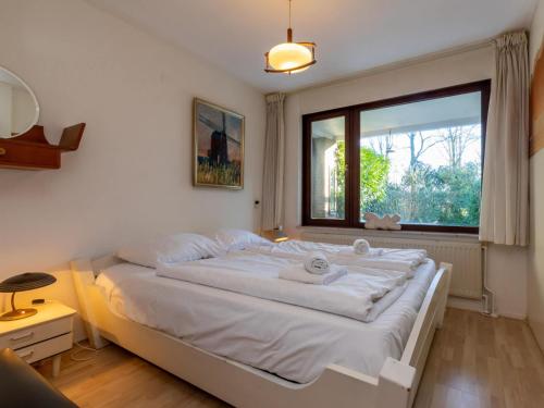 a bedroom with a large white bed with a window at Holiday Home in Veere near Historic Center in Veere