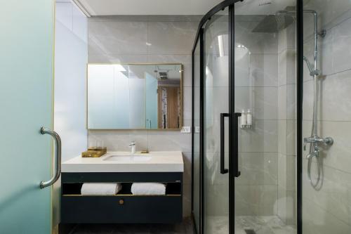 a bathroom with a sink and a glass shower at Sunlight Guest Hotel in Puerto Princesa City