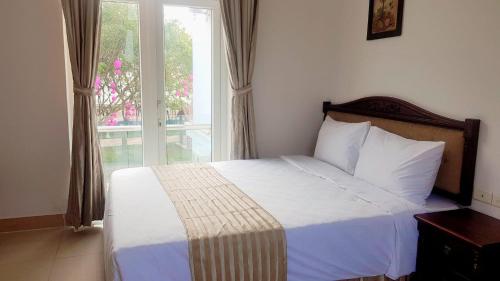 a bedroom with a large bed with a window at Sen Vàng in Diễn Châu